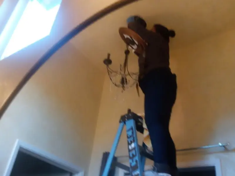 Electrician installing a chandelier in a Ladera Ranch residence